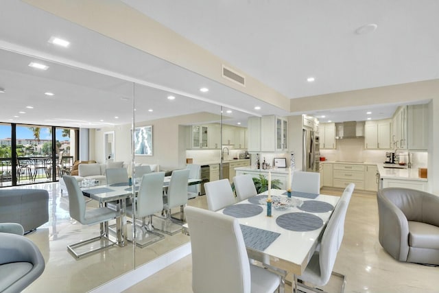 dining area featuring light tile patterned floors, floor to ceiling windows, and sink