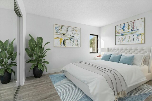 bedroom featuring wood-type flooring, a textured ceiling, and a closet