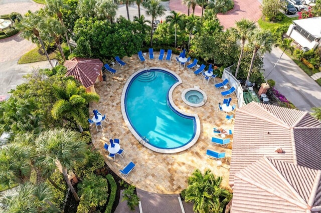 view of swimming pool featuring a hot tub and a patio area