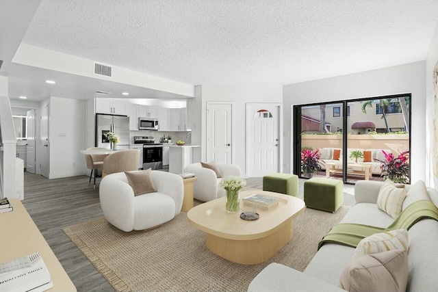 living room with hardwood / wood-style flooring and a textured ceiling