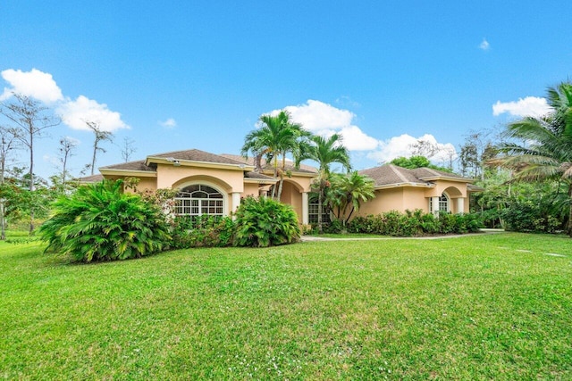 mediterranean / spanish home with a front lawn