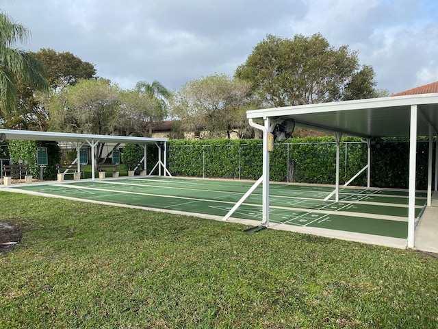 view of property's community featuring a yard, shuffleboard, and fence