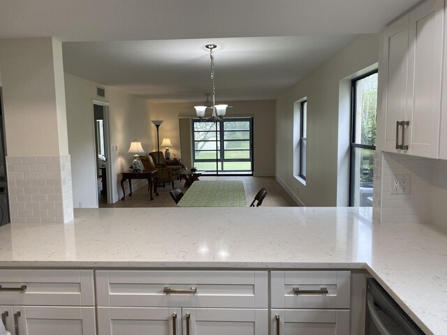 kitchen with light stone counters, light wood-type flooring, a sink, stainless steel appliances, and tasteful backsplash