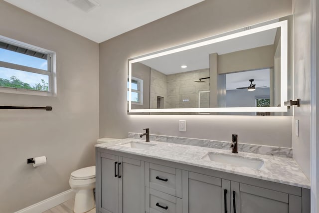 bathroom featuring a tile shower, vanity, ceiling fan, hardwood / wood-style flooring, and toilet