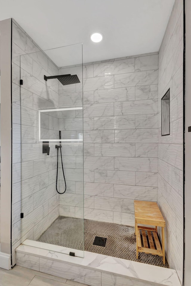 bathroom with tile patterned flooring and tiled shower