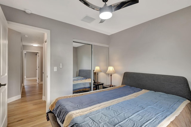 bedroom featuring ceiling fan, a closet, and light hardwood / wood-style flooring