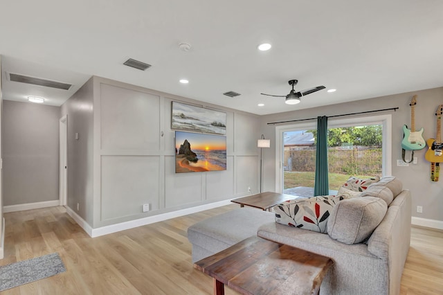 living room with ceiling fan and light hardwood / wood-style flooring