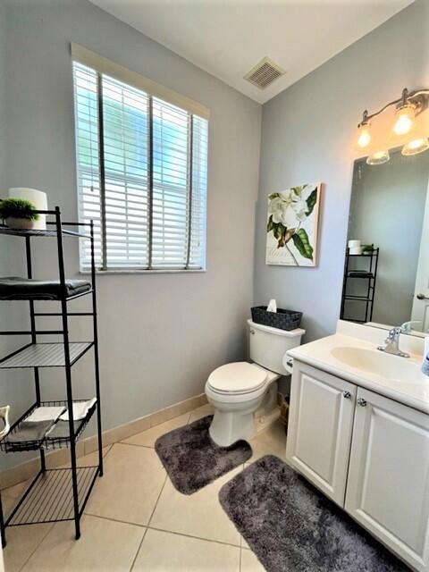 bathroom with tile patterned flooring, vanity, and toilet