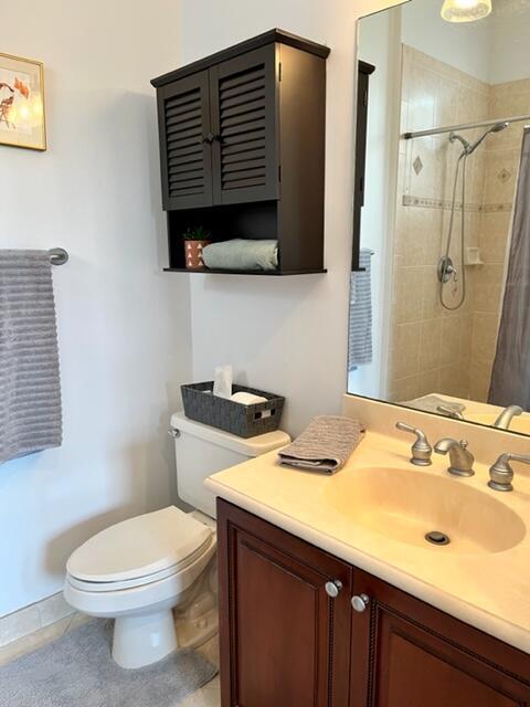 bathroom with a shower with shower curtain, vanity, toilet, and tile patterned floors