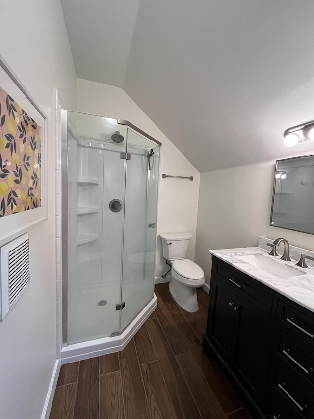 bathroom with vanity, toilet, lofted ceiling, and walk in shower