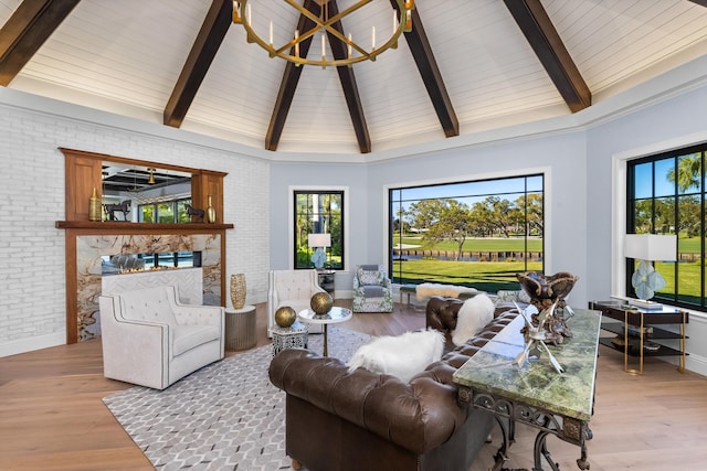 living room with light wood-type flooring, high vaulted ceiling, brick wall, and beam ceiling