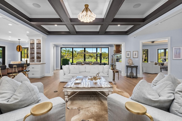 living room featuring crown molding, beam ceiling, coffered ceiling, light hardwood / wood-style floors, and a chandelier