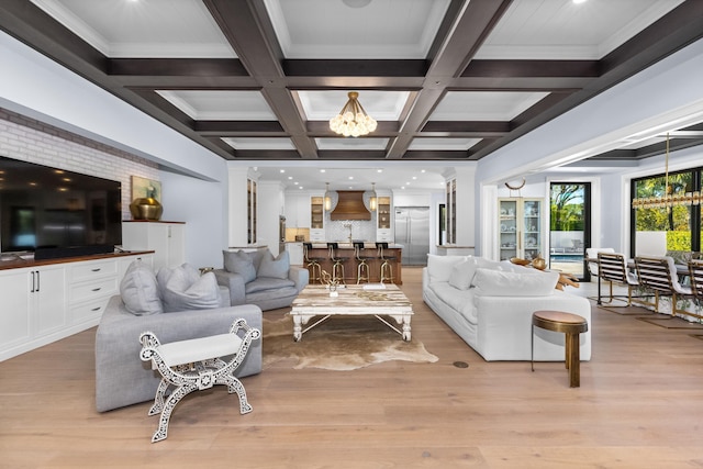 living room with light hardwood / wood-style flooring, beam ceiling, a notable chandelier, and coffered ceiling