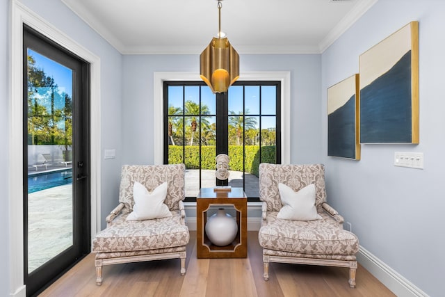 living area featuring crown molding and hardwood / wood-style flooring