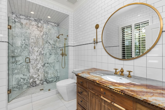 bathroom with tile walls, toilet, a shower with shower door, vanity, and ornamental molding