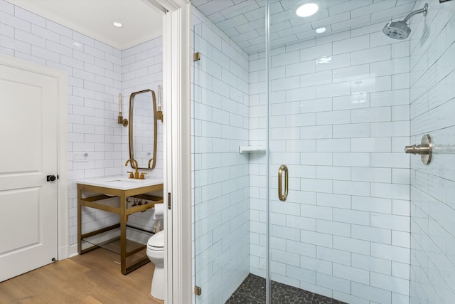 bathroom featuring hardwood / wood-style floors, toilet, an enclosed shower, and tile walls