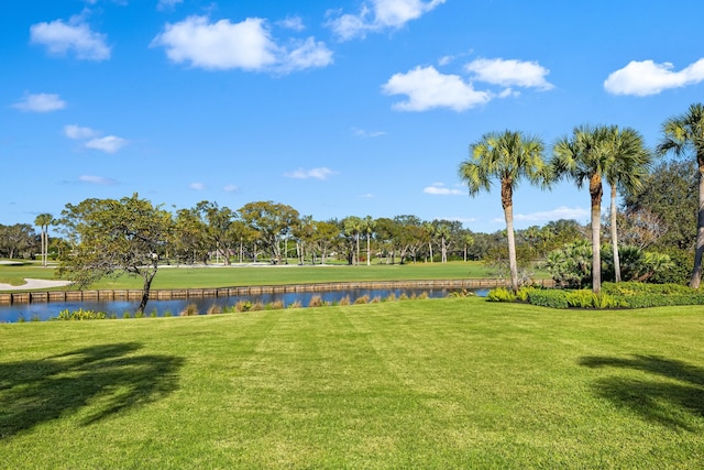 view of property's community with a lawn and a water view