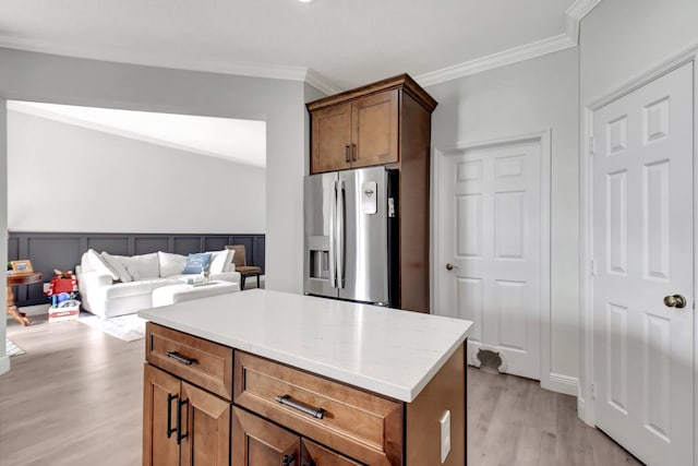 kitchen with stainless steel fridge, a center island, light hardwood / wood-style flooring, and crown molding