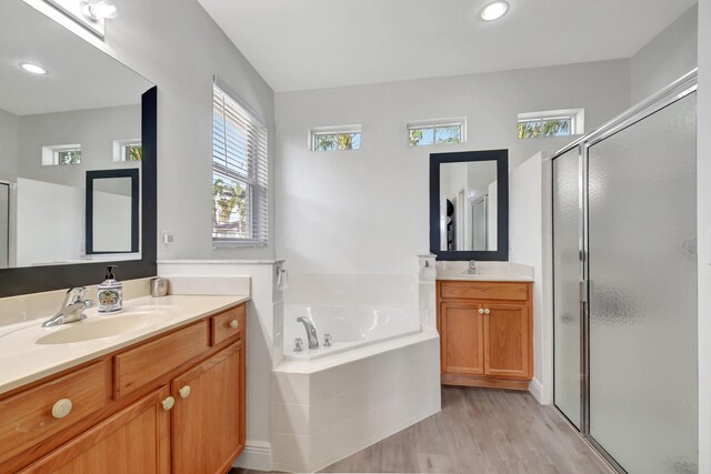 bathroom with hardwood / wood-style floors, vanity, a healthy amount of sunlight, and separate shower and tub