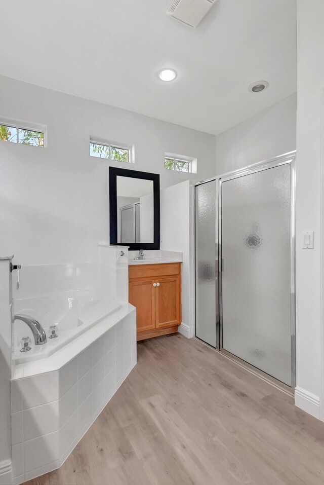 laundry room with washer and dryer, light hardwood / wood-style floors, and cabinets