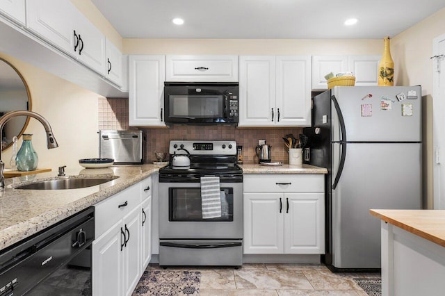 kitchen featuring decorative backsplash, light stone counters, sink, black appliances, and white cabinets