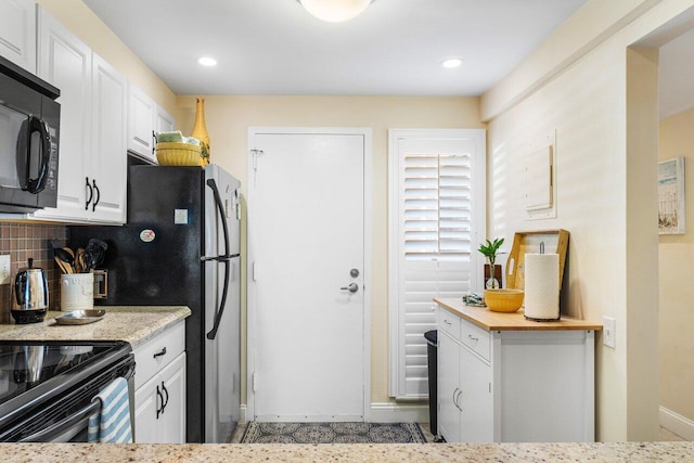 kitchen featuring backsplash, white cabinets, and black appliances