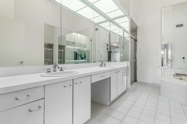 bathroom with tile patterned flooring, shower with separate bathtub, and vanity