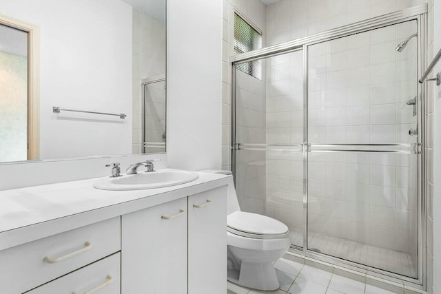 bathroom featuring tile patterned flooring, vanity, toilet, and a shower with shower door