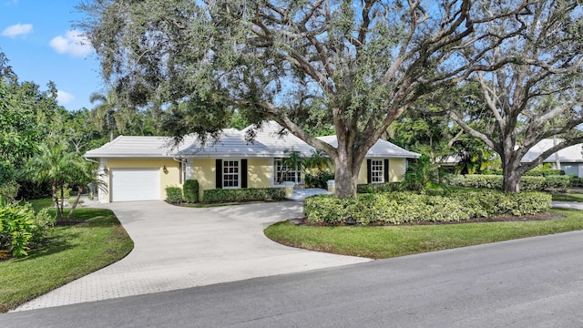 ranch-style house featuring a garage and a front lawn