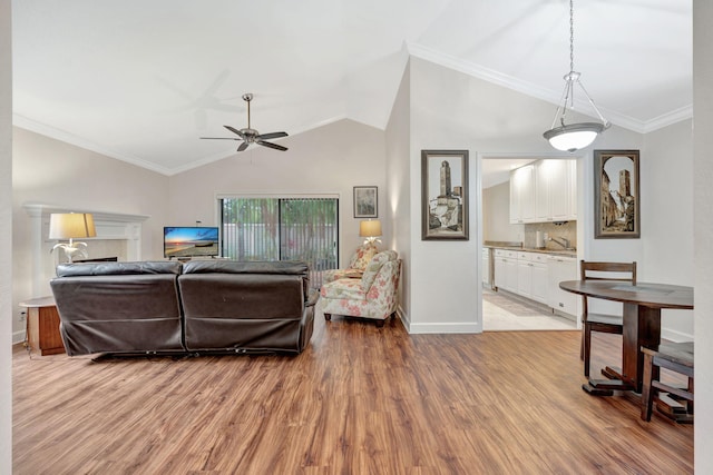 living room with light wood-type flooring, vaulted ceiling, ceiling fan, and crown molding