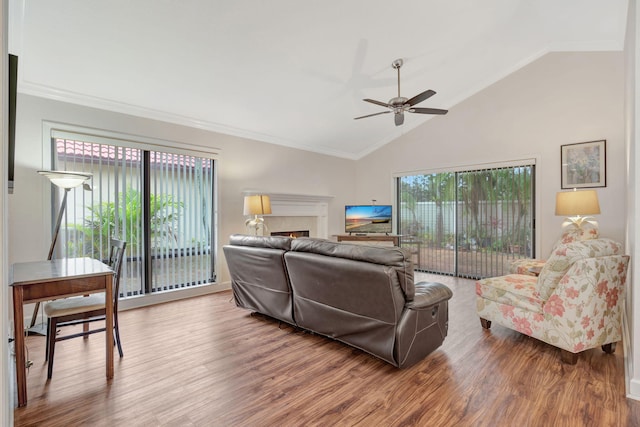 living room featuring hardwood / wood-style flooring, high vaulted ceiling, ceiling fan, and crown molding