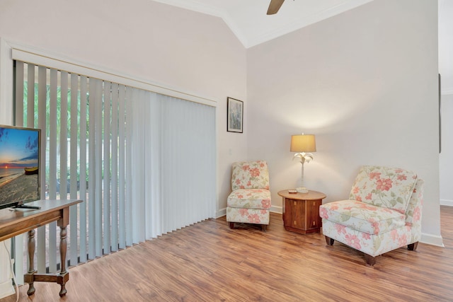 living area featuring crown molding, hardwood / wood-style floors, vaulted ceiling, and ceiling fan