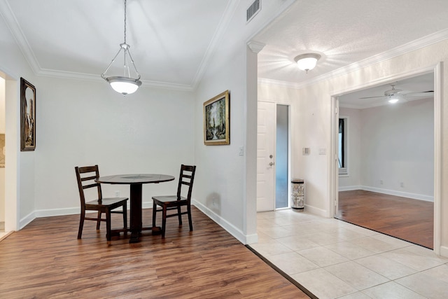 dining area with light hardwood / wood-style floors, ornamental molding, and ceiling fan