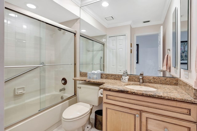 full bathroom featuring toilet, vanity, crown molding, and combined bath / shower with glass door