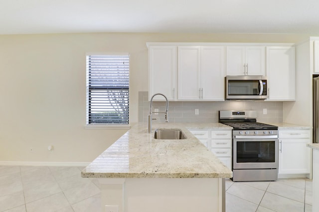 kitchen with backsplash, sink, appliances with stainless steel finishes, light stone counters, and white cabinetry