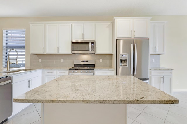 kitchen with white cabinets, backsplash, stainless steel appliances, and sink