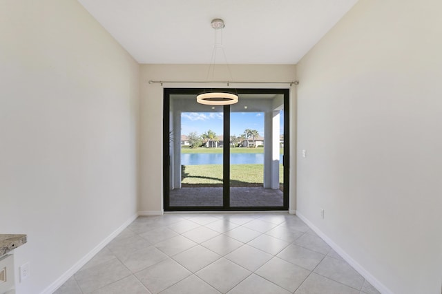 interior space featuring a notable chandelier, a water view, and light tile patterned floors