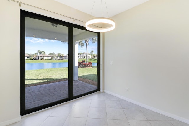 doorway to outside featuring a water view and light tile patterned floors