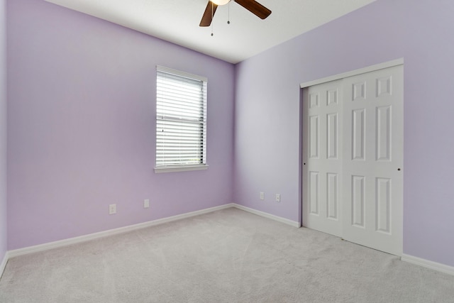 unfurnished bedroom with light carpet, a closet, and ceiling fan