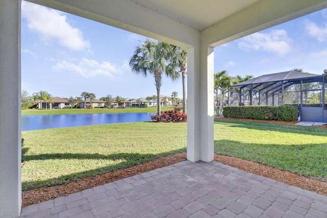 view of yard featuring a lanai, a water view, and a patio