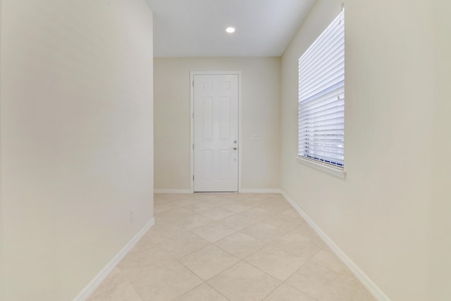 empty room with light tile patterned floors and plenty of natural light