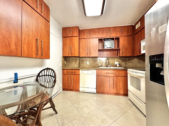 kitchen with light tile patterned floors, white appliances, backsplash, and sink