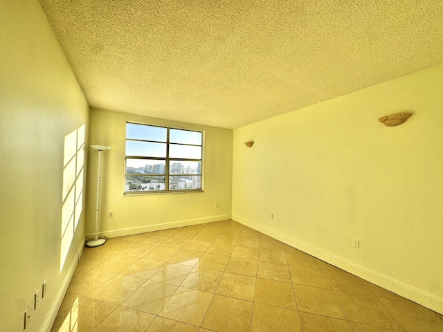 tiled spare room with a textured ceiling