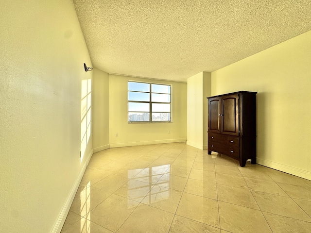 tiled spare room with a textured ceiling