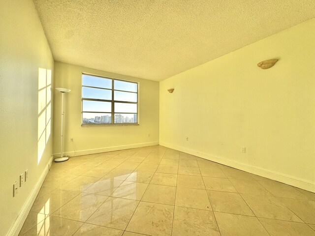 unfurnished room featuring light tile patterned floors and a textured ceiling