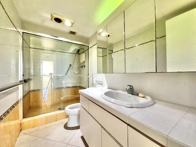 bathroom with tile patterned floors, vanity, toilet, and walk in shower