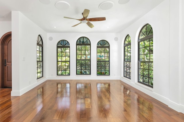 empty room featuring hardwood / wood-style flooring, ceiling fan, and plenty of natural light