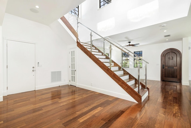 foyer with a high ceiling, dark wood-type flooring, and ceiling fan