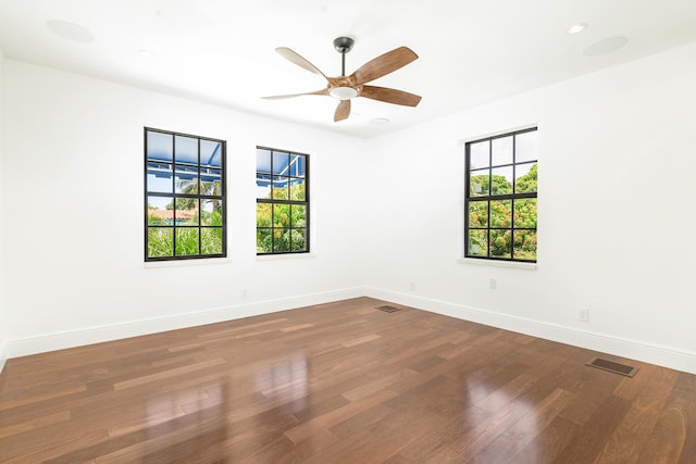 unfurnished room with ceiling fan, a healthy amount of sunlight, and wood-type flooring