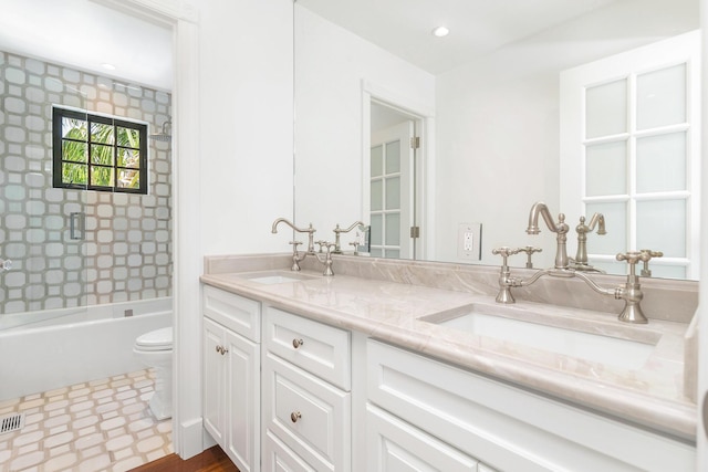 full bathroom featuring vanity, toilet, and tiled shower / bath